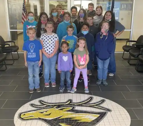 children standing in group with evant logo