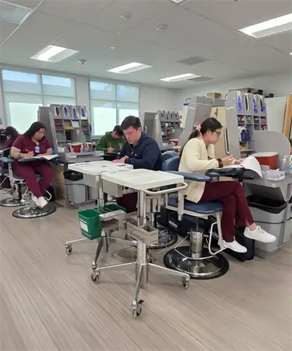 Phlebotomy students practice in the lab