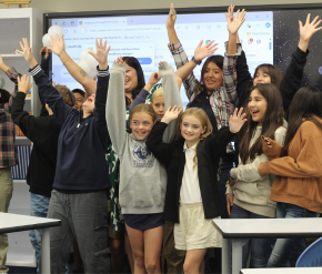 Children celebrating with their hands up in the air all smiling and happy