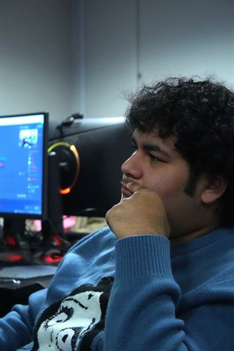 Student sitting next to computer monitor.
