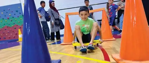 Student on a gym scooter having fun with an activity at Summer Feast