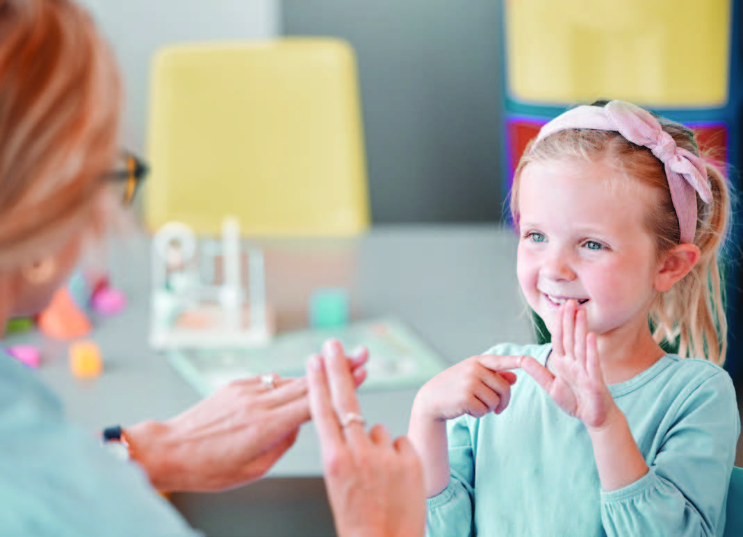 Young Student Practicing Signing for Hard of Hearing with Teacher
