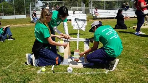 Students make adjustments to their catapult during the Surge Showdown event at STEM Games