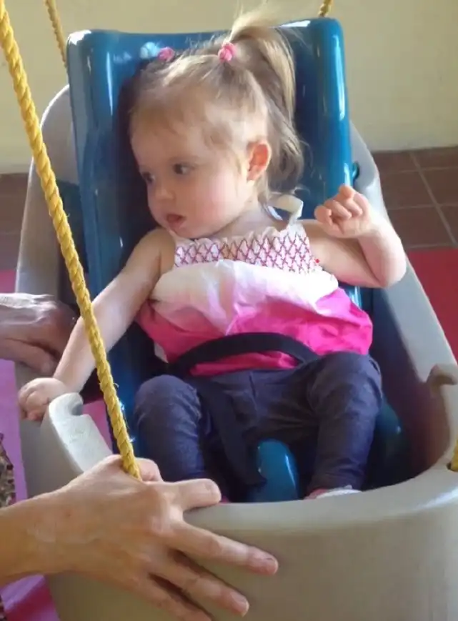 Emerson learning to raise her hand to indicate she wanted more swinging