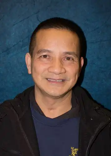 Ba in front of blue backdrop