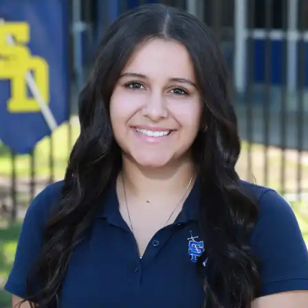 Female student profile wearing a blue San Dimas High School polo shirt with school emblem.