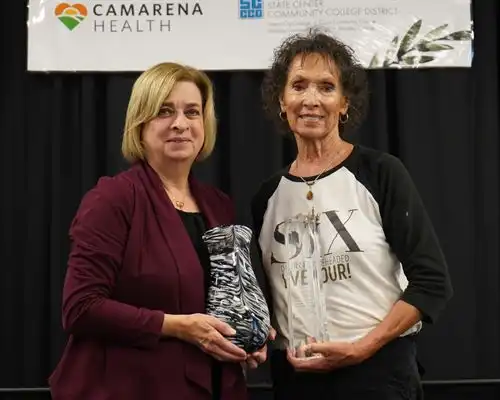 Cecilia Massetti holding a black and white vase and Ginger Latimer with her Crystal Tower Award