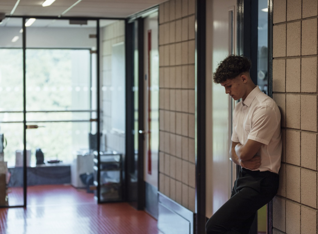 Photo of student waiting in hallway