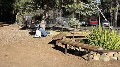 Person reading and relaxing in a chair by a pond with a fountain
