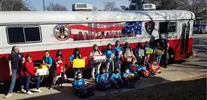 Students in front of bus with donated goods.