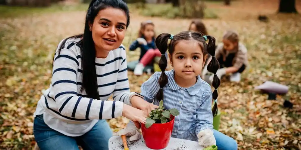 volunteer helping student plant garden
