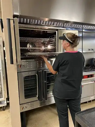 Kitchen staff with new industrial oven, 2022