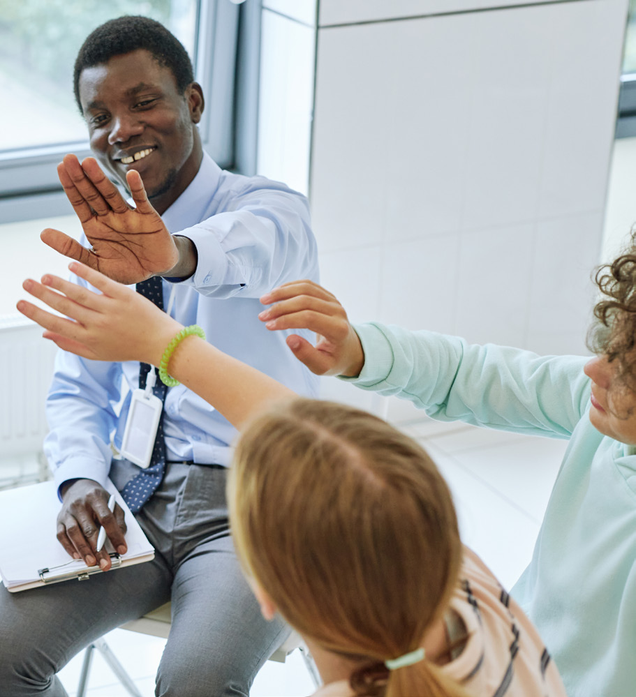 Photo of teacher giving "high-five" to students