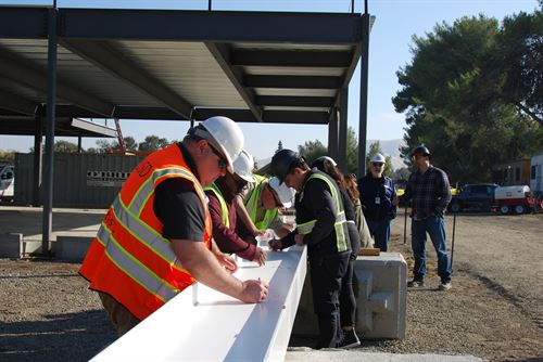 Construction crew signing the last beam