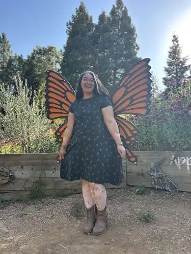 Person with monarch wings standing outside
