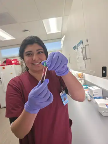 Phlebotomy student shows blood in a vial