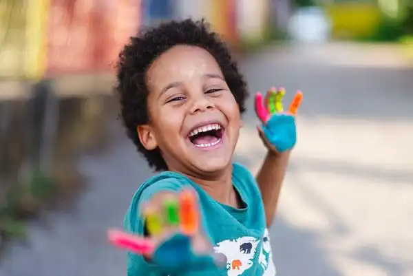 Child with Paint On his Hands Laughing