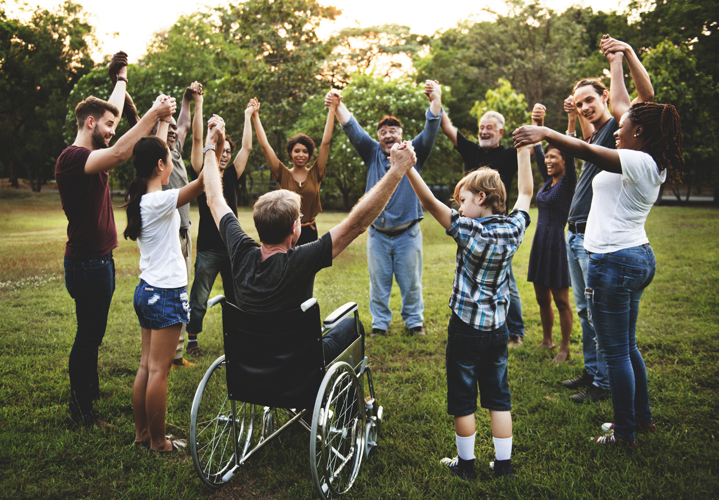 Photo of a group of diverse people holding hands in a circle.