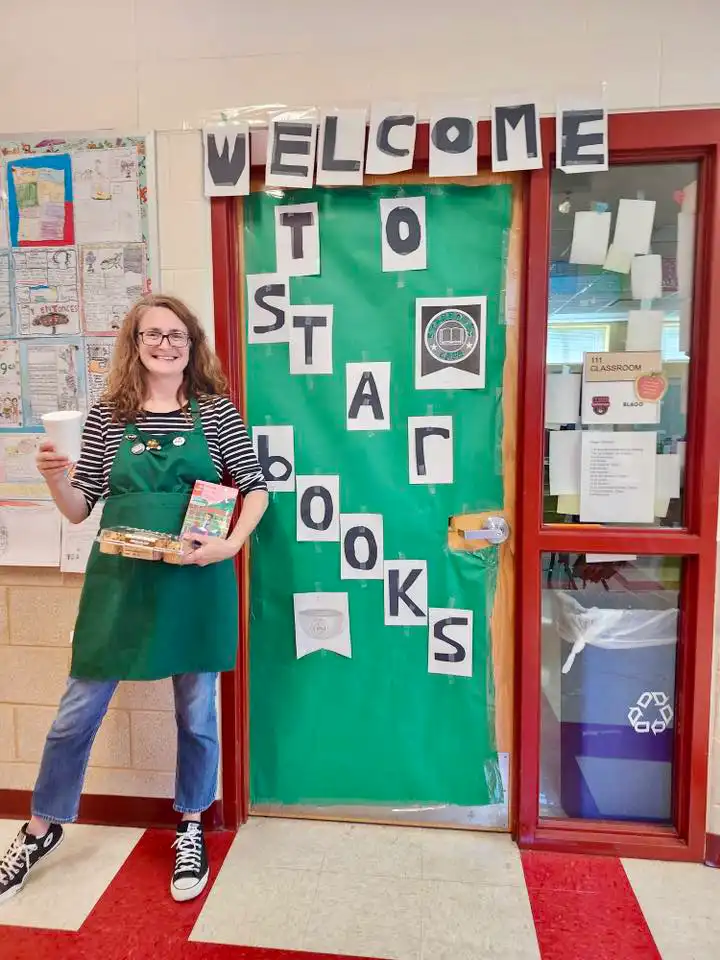 teacher in front of door with a Star books theme