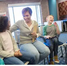 Counselor smiling at a student. Student laughing in background.