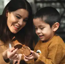 Woman and child holding chocolate chip cookies