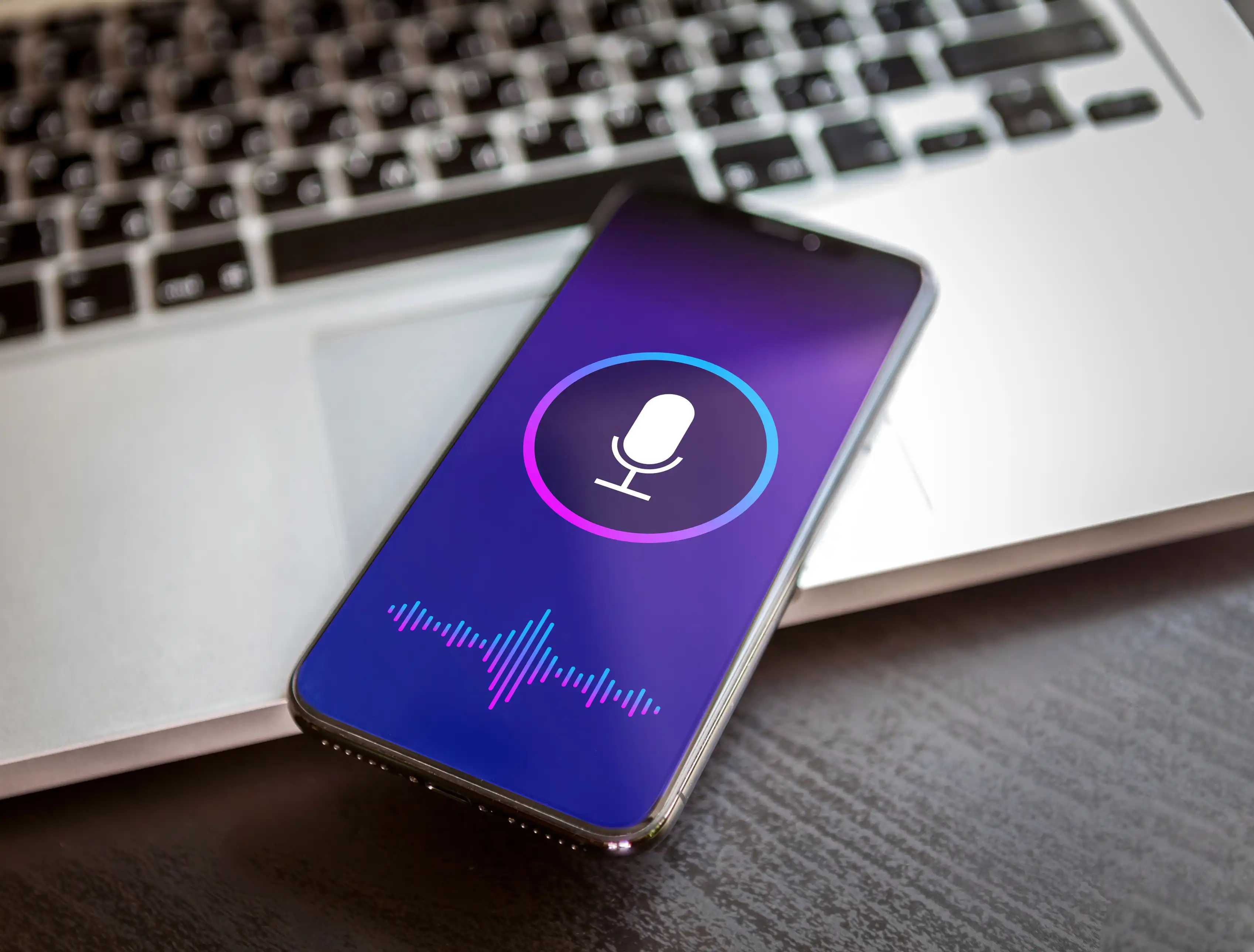 A photo of a smartphone with a microphone symbol on its screen