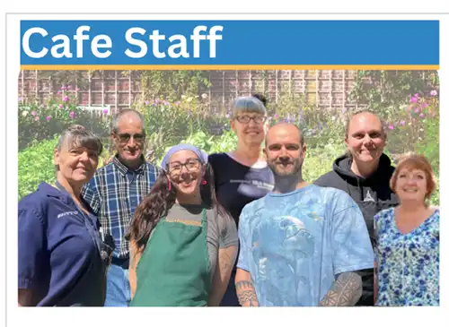 Seven individuals smiling in the sunshine with a garden faded in the background