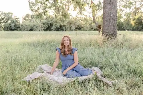 Kathryn Wolf sitting on a blanket in a medow