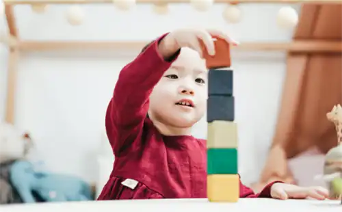 CHIDLREN PALYING WITH WODDEN BLOCKS