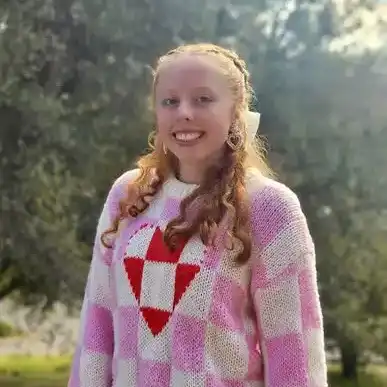 A photo of Emily Kirby wearing a pink and white checker sweater