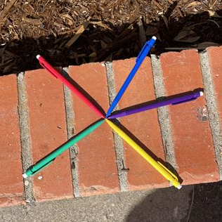 five multi-colored mechanical pencils on bricks