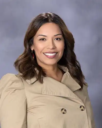 female wearing a jacket and smiling